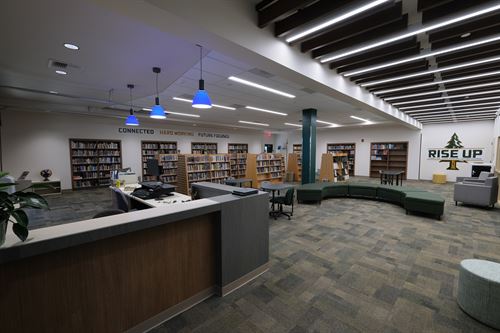 interior of library with a desk on the left and book stacks in the background