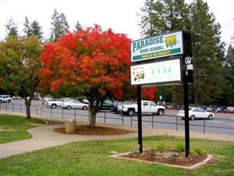 Front of PHS with tree with red leaves and PHS sign